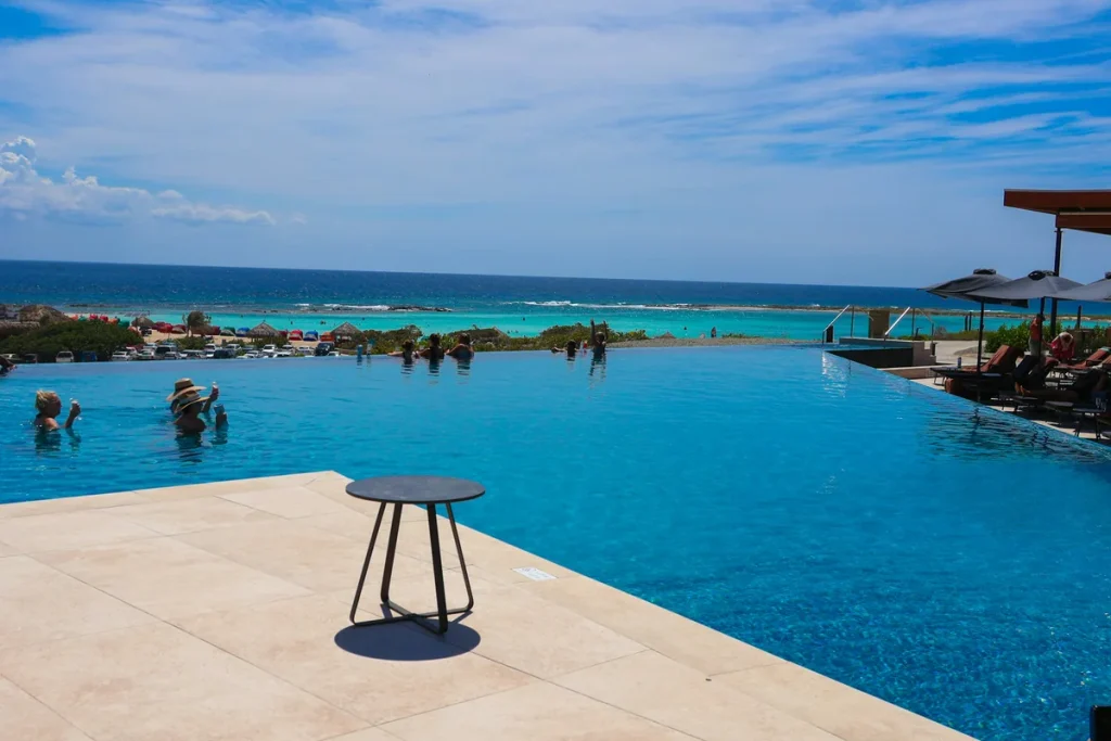 Infinity pool overlooking the turquoise Caribbean Sea at Secrets Baby Beach Aruba adults-only resort.