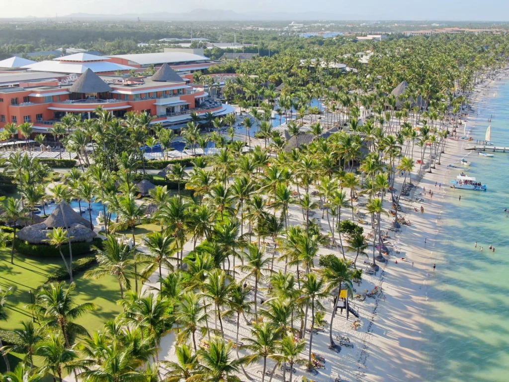 Aerial view of a Caribbean beachfront resort with palm trees, white sand and turquoise water